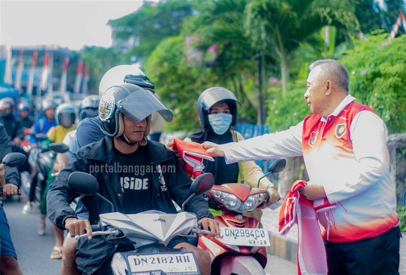 Wabup Banggai H. Furqanuddin saat pembagian bendera ke warga yang lewat